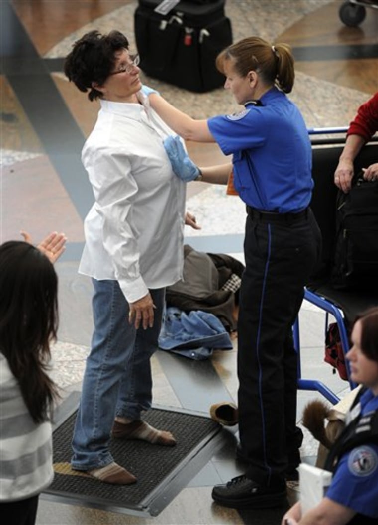 A Transportation Security Administration agent performs an enhanced pat-down Wednesday on a traveler at a security area at Denver International Airport in Denver.